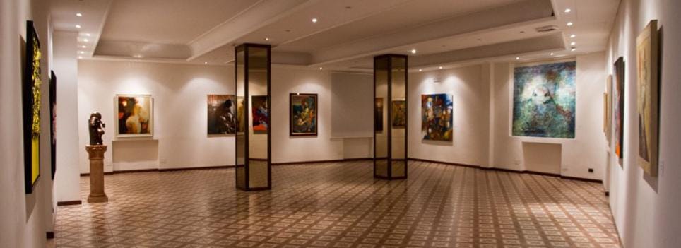 A long gallery of the Chianciano Art Museum, chequered marble underfoot.