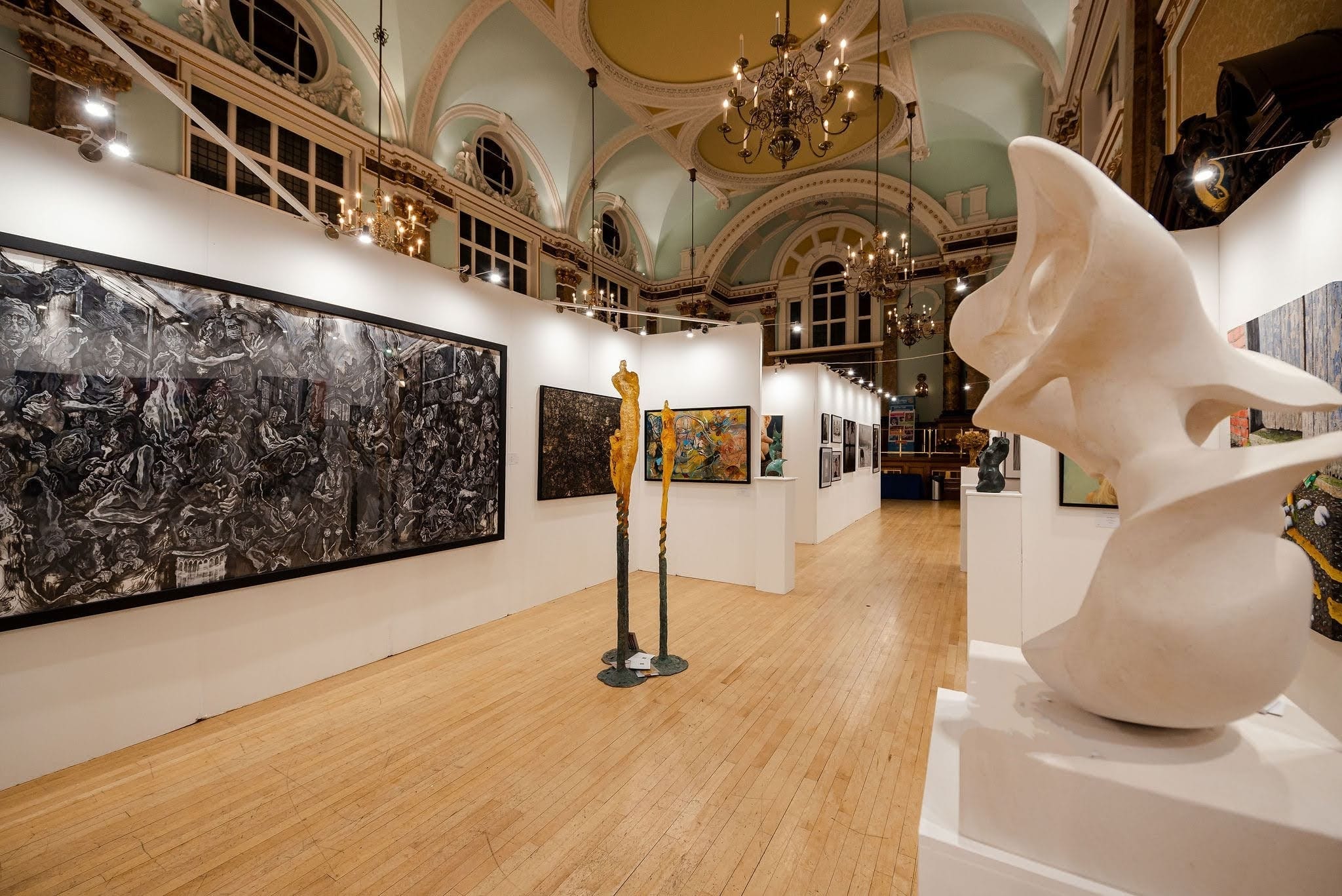 The Sixth Edition: temporary white walls hung with paintings down the length of the main hall, bronze figures and a large pale stone sculpture standing among them beneath the gilded ceiling.