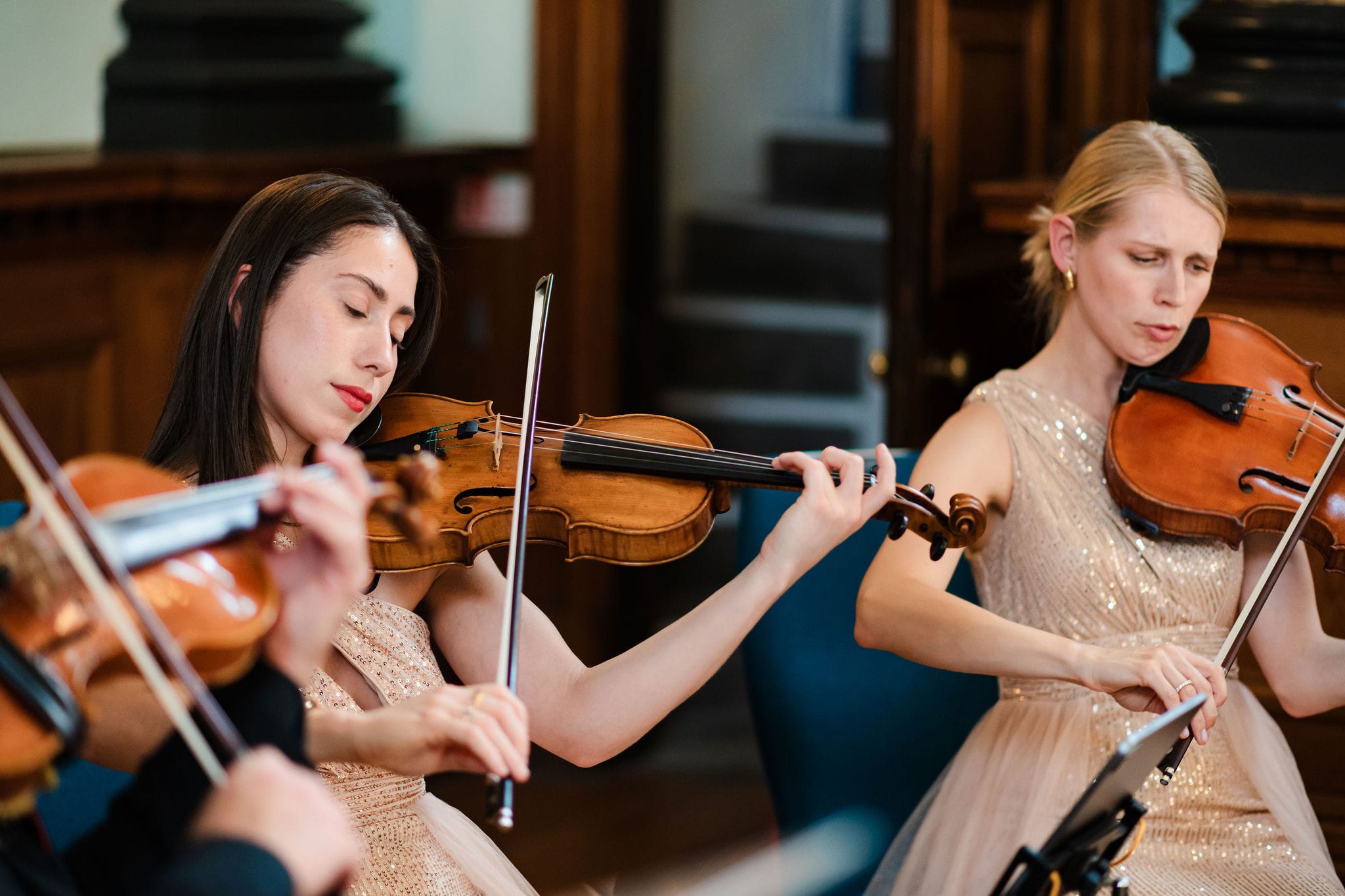 Two violinists of the string quartet playing at the Biennale, in gold evening dress.