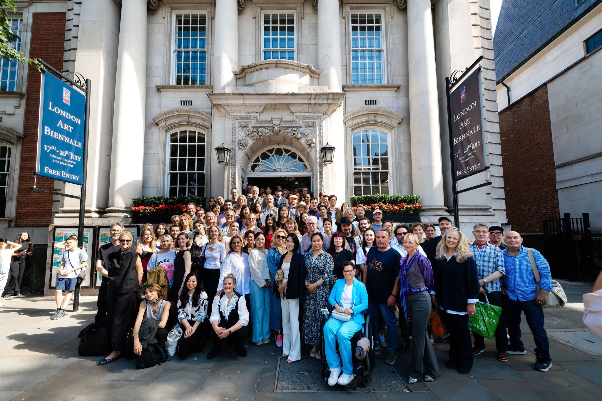 Exhibiting artists gathered on the steps of Chelsea Old Town Hall beneath the Biennale banners.
